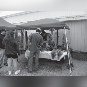 Brandon Skratsky (right) tells a customer about one of the animal pelts offered. His brother, Sebert, also helped customers.